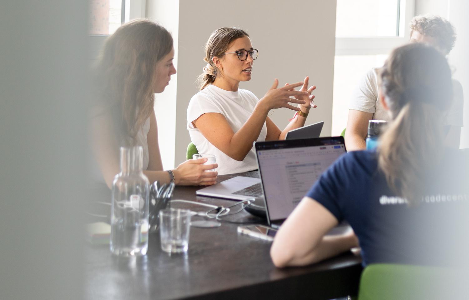 Projektmitglieder diskutieren gemeinsam in einem Meetingraum.