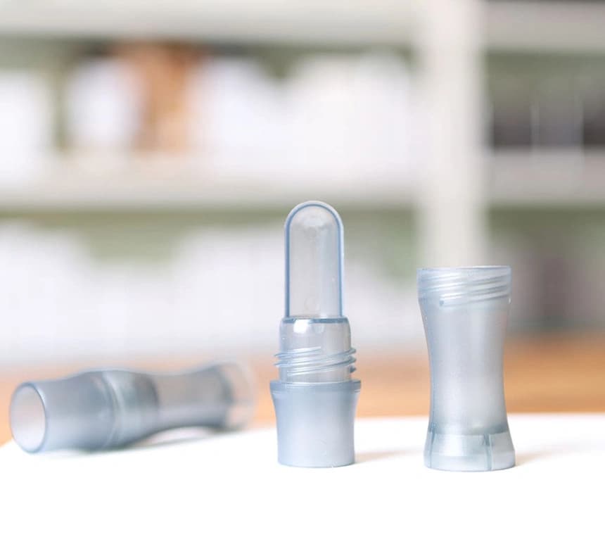 An empty bottle for a cosmetic product stands on a table