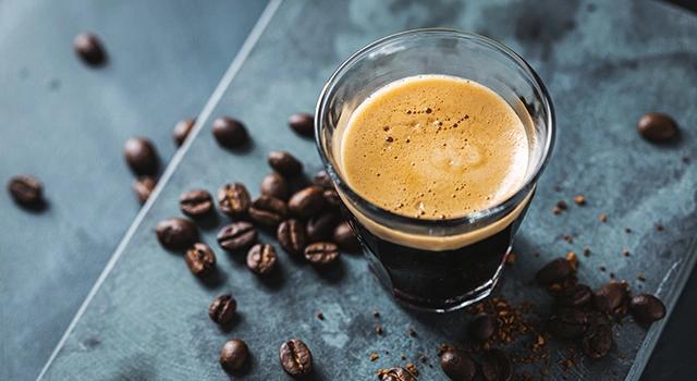 Glas Kaffee mit Kaffeebohnen