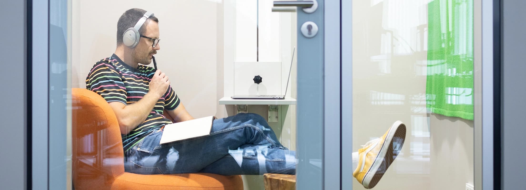 codecentric Mitarbeiter, der an einem Webinar teilnimmt und sich dazu Notizen macht.