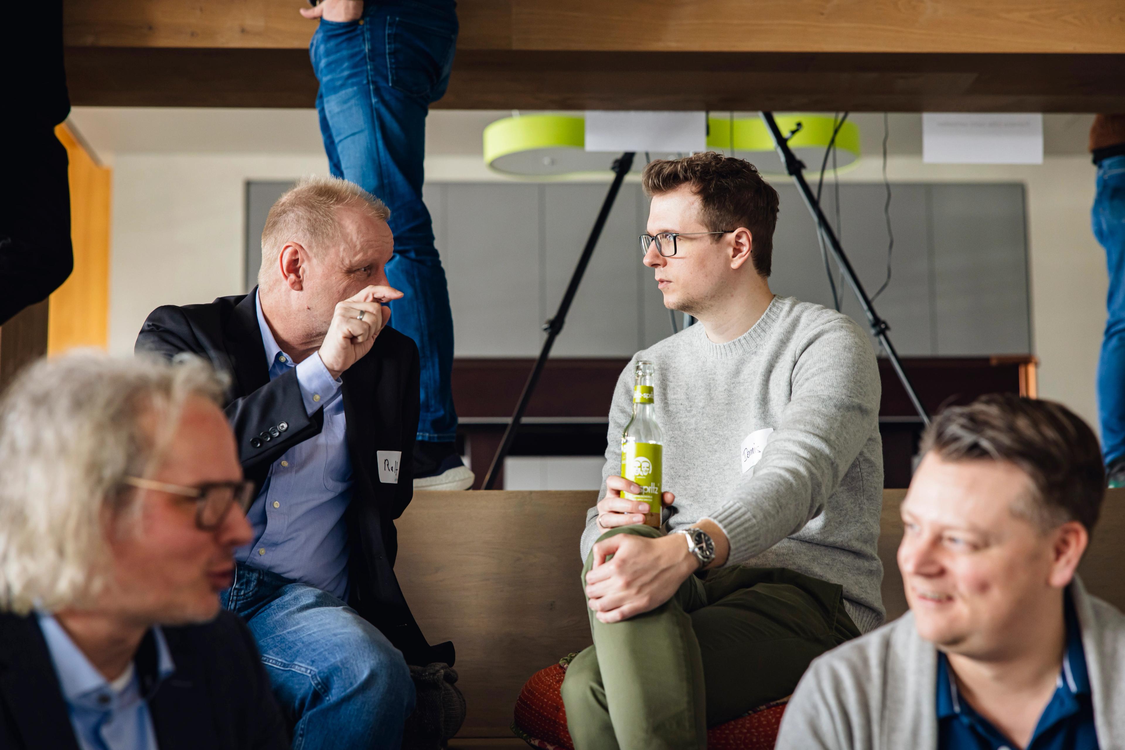 Eine Person die einer weiteren etwas erklärt im Auditorium in Solingen, beim Event des Business Acceleration Club.