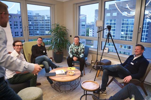 Gruppe diskutiert in Fenster-Sitzecke beim Business Acceleration Club