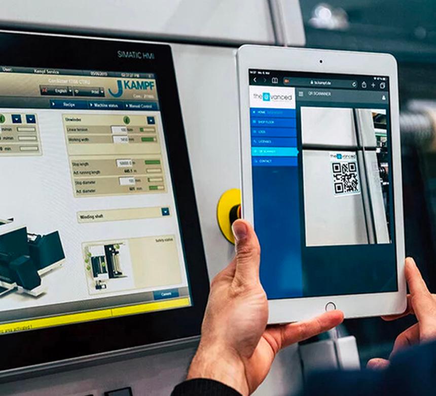 Eine Maschine mit einem Display und einem QR-Code, der von einer Person mit Tablet gescannt wird.