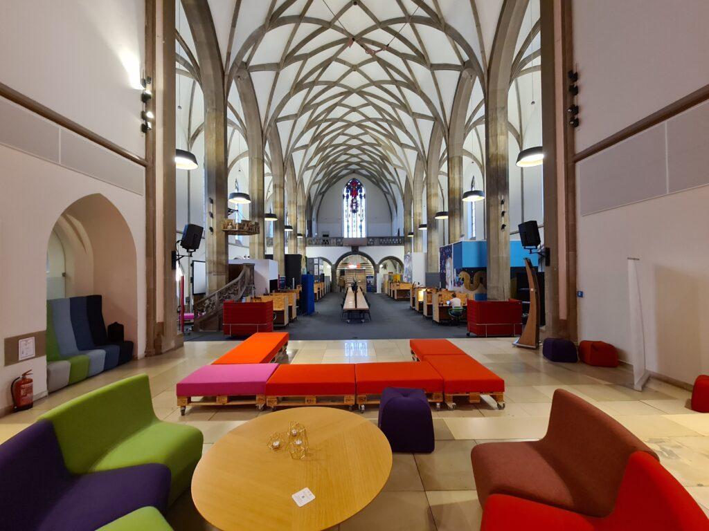 Coworking-Kirche als Büro-Fläche und Vorraum als Meetingpunkt mit Sitzecke