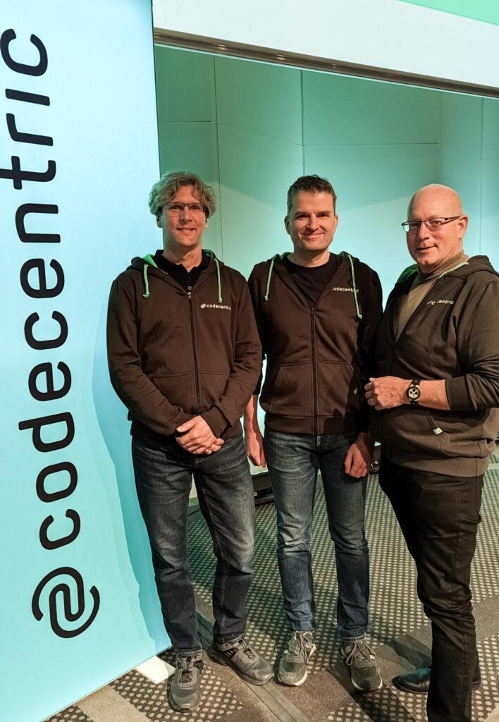 Lars Rückemann, Rainer Vehns und Stefan Riedel, neben codecentric Banner beim Kickoff 2023.